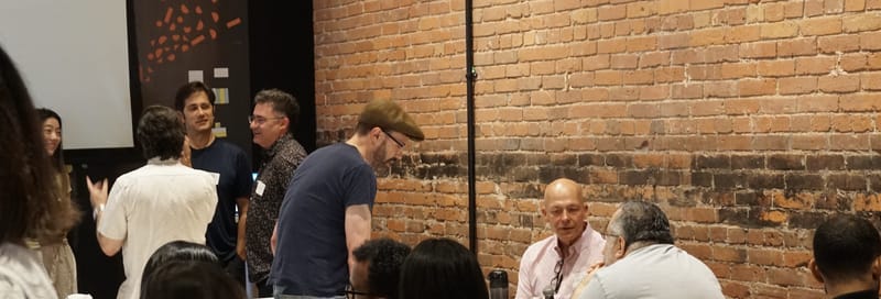 People standing and talking against the brick wall after the talks.