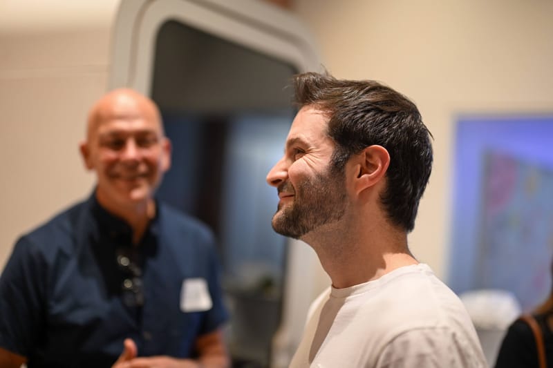 Two attendees talking and laughing in the workspace after the talks.