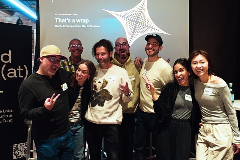 Nine people grinning and throwing peace signs in front of a projected slide reading That's a wrap with the Frontier Creatives star on it.